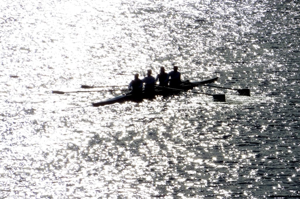 Men rowing canoe sunny day
