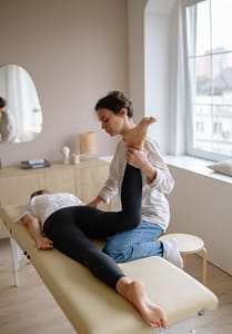 physiotherapist holding patients leg